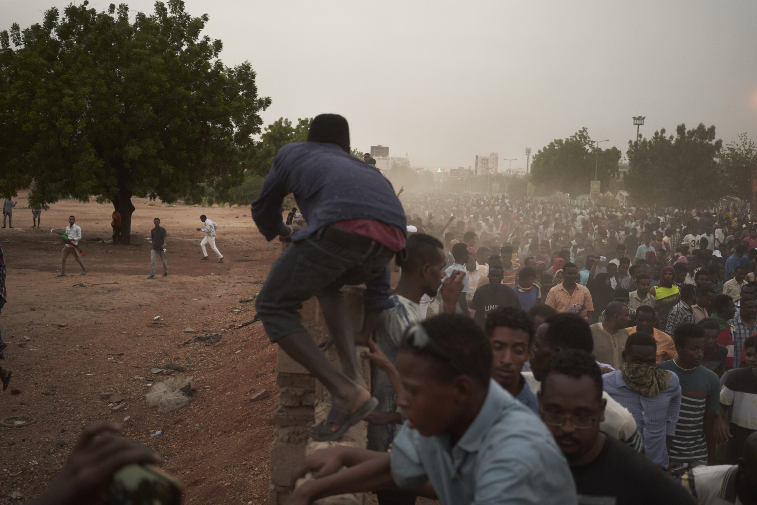 Protesters run from the sounds of gunshots and teargas
