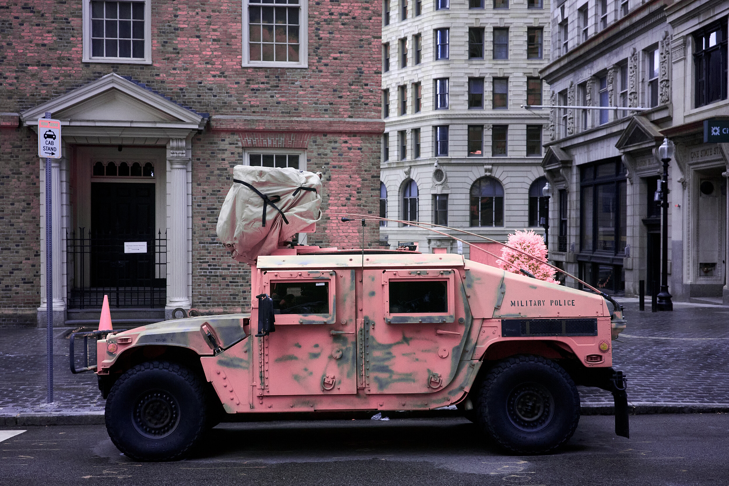 An infrared photo from downtown Boston showing a pink Humvee parked in a cab stand spot.