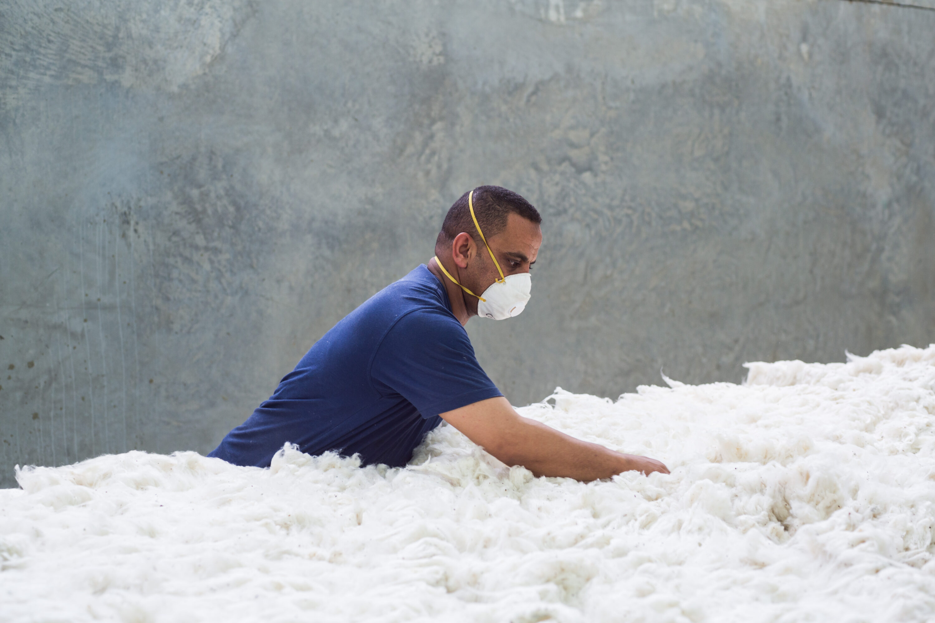 Factory worker inspecting denim fabric quality on a production line