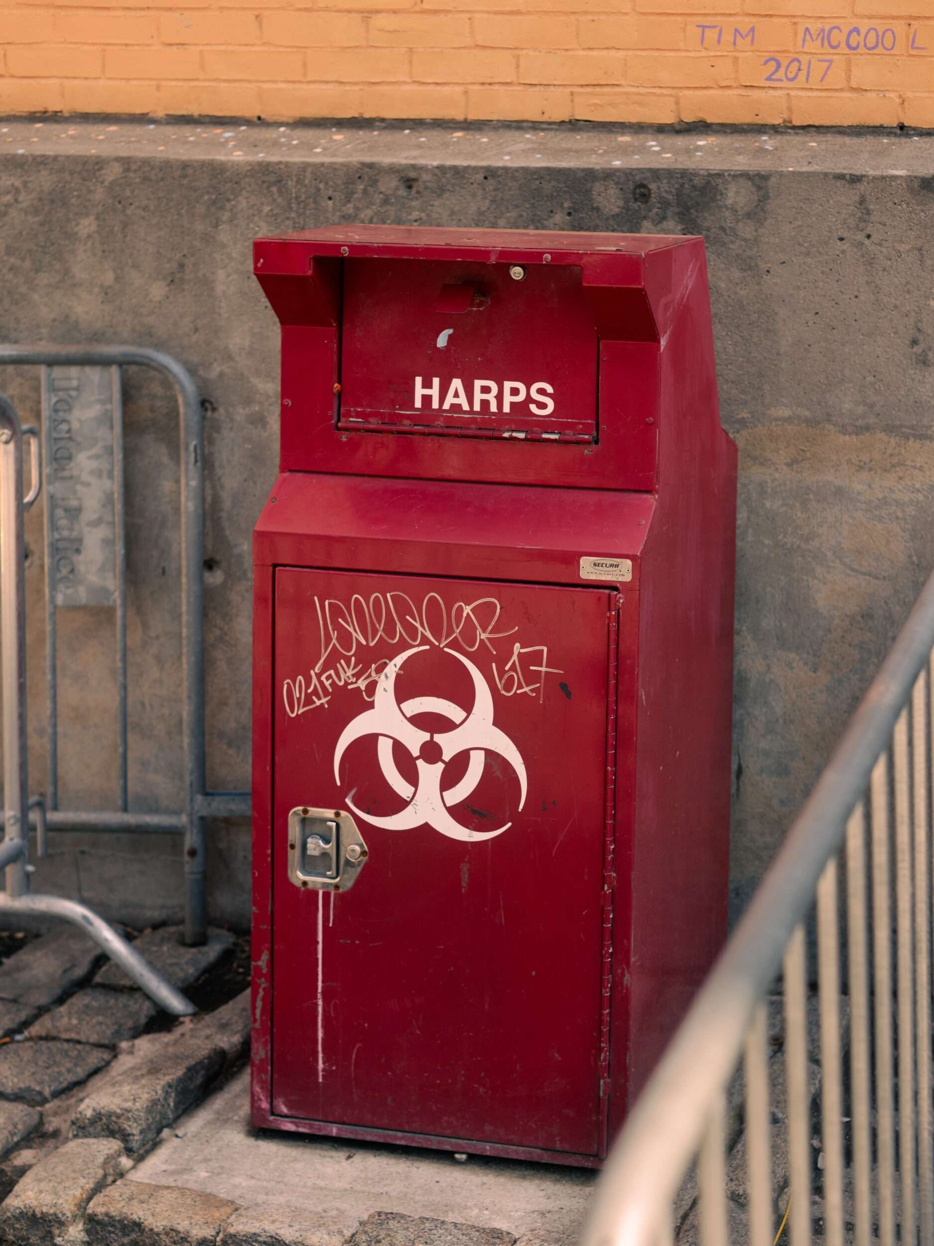 A graffitied sharps disposal container marked with a biohazard symbol stands outside the AHOPE needle exchange in Boston A graffitied sharps disposal container marked with a biohazard symbol stands outside the AHOPE needle exchange in Boston