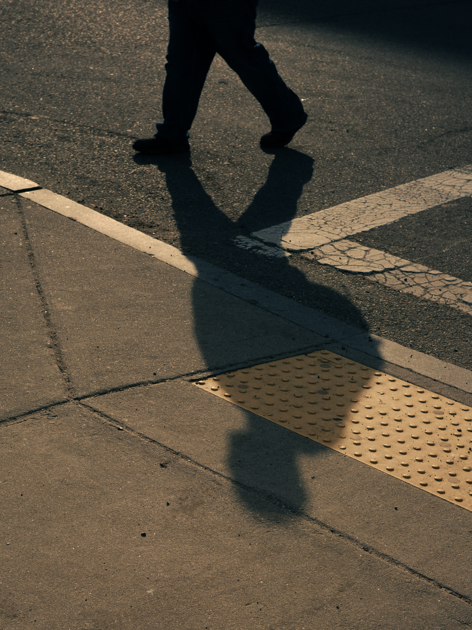 The shadow of a person crossing the street at the intersection of Massachusetts Avenue and Melnea Cass Boulevard in Boston The shadow of a person crossing the street at the intersection of Massachusetts Avenue and Melnea Cass Boulevard in Boston