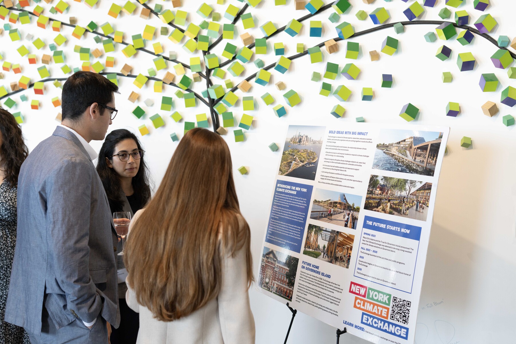 Attendees talk beside a climate project display.