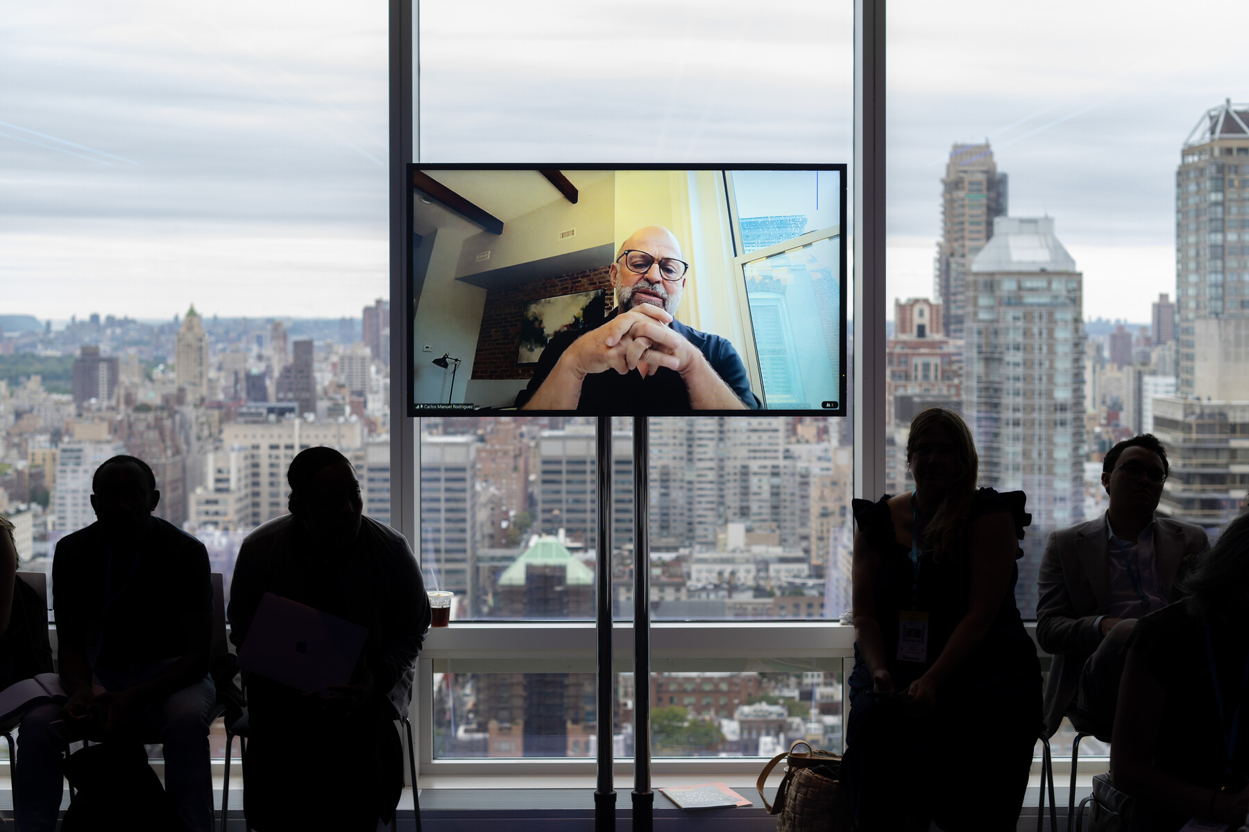 Panel participants are silhouetted against the New York skyline.
