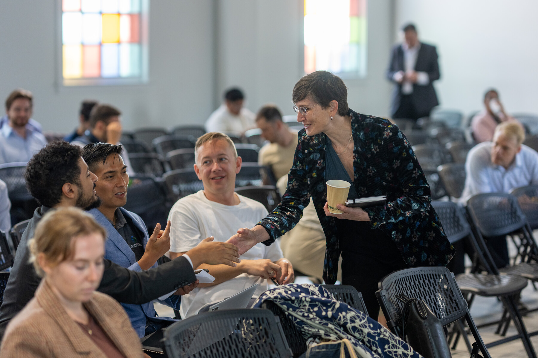 An attendee reaches to greet another in the audience.