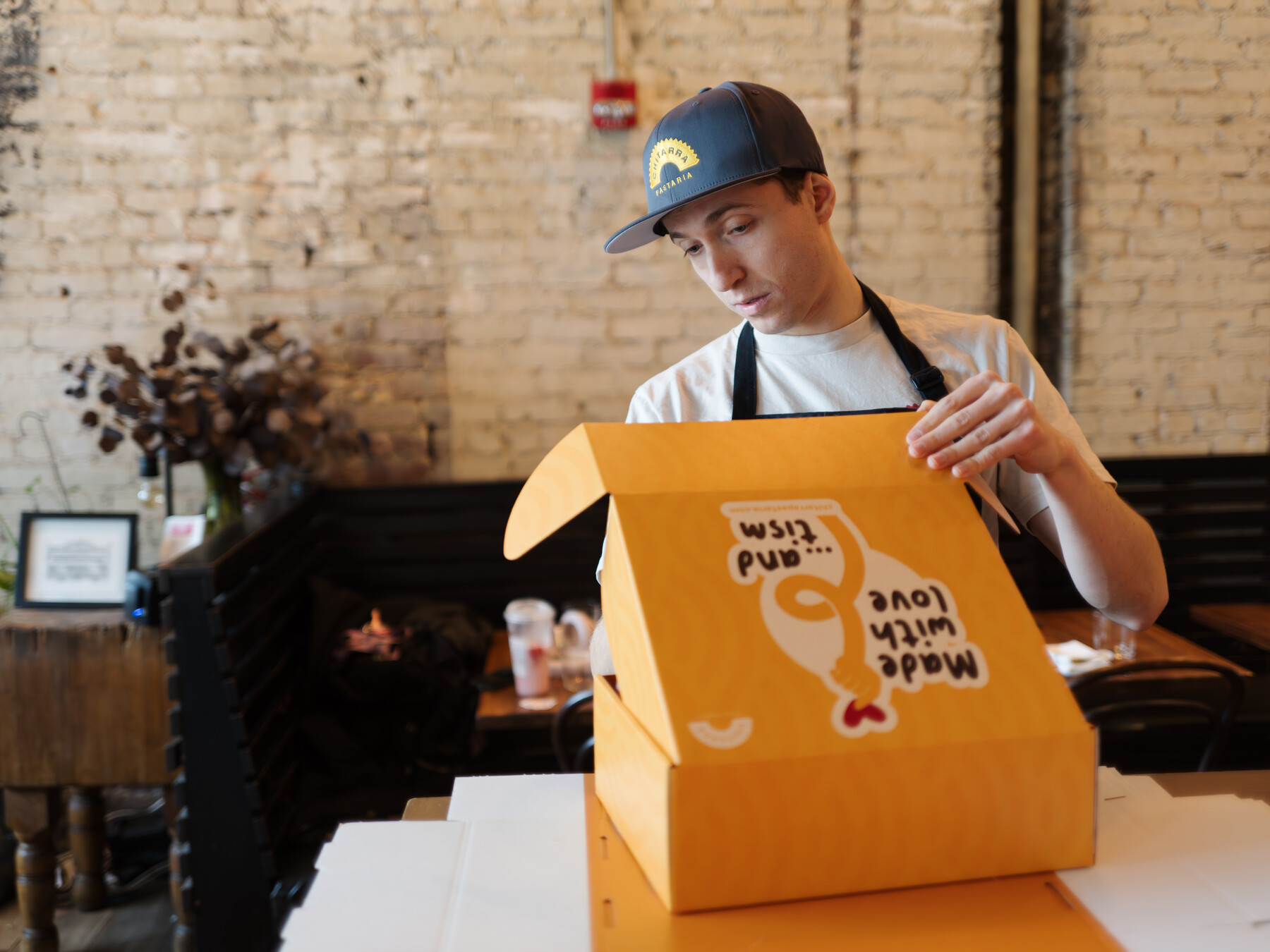 Stefano Micali looks into an orange Chitarra pasta box.