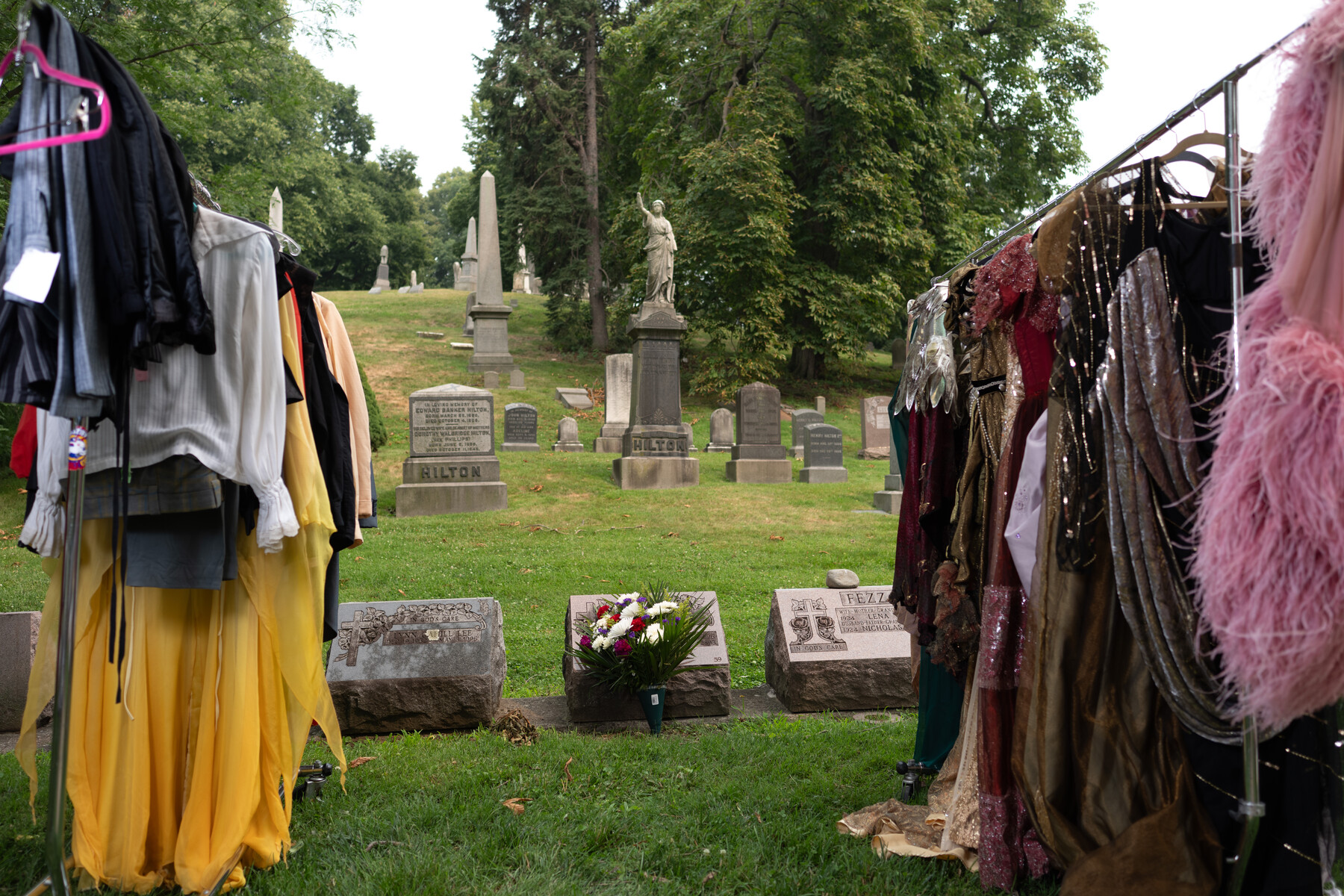 Costumes hang on racks between gravestones before the circus performance.