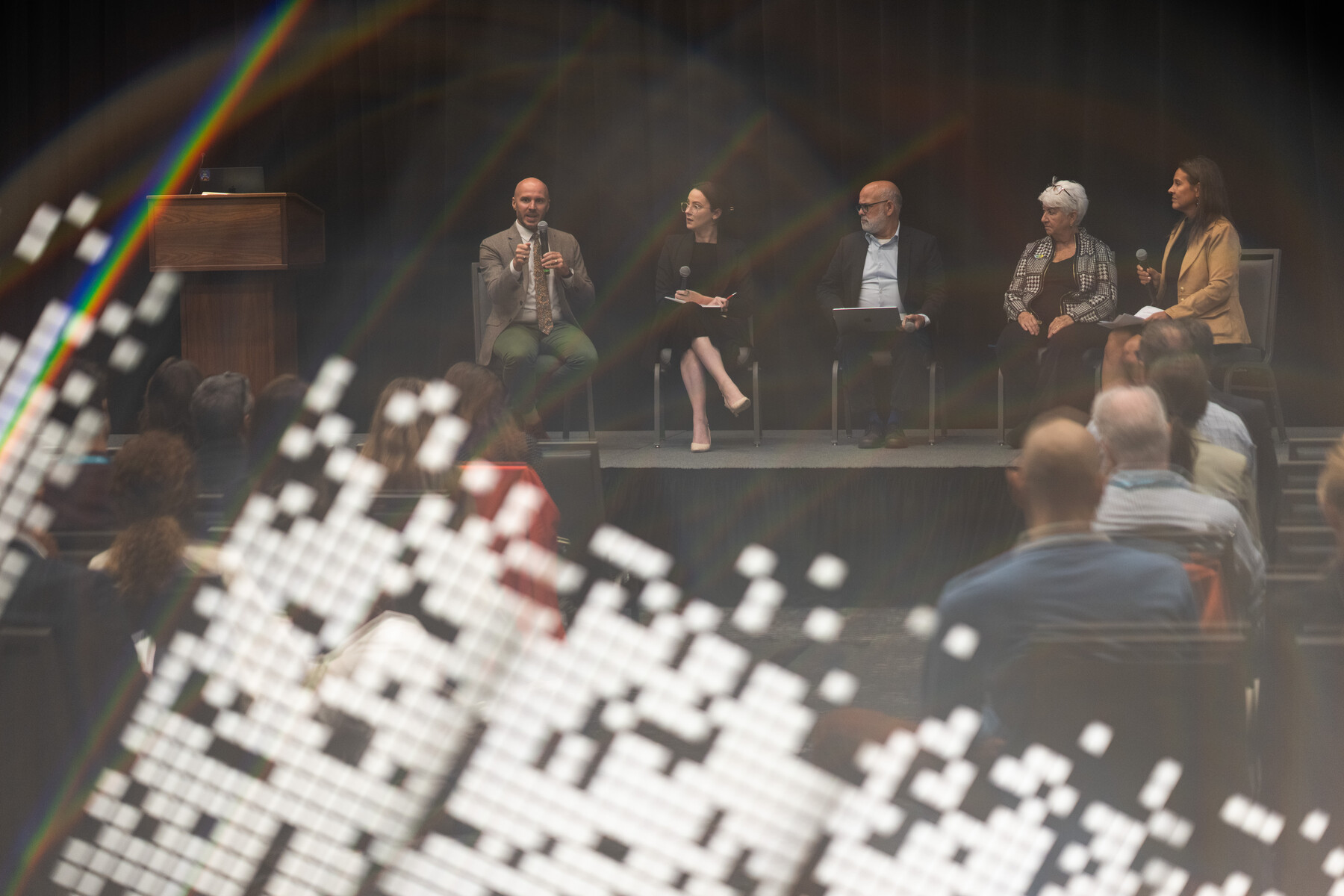 A resilience panel seen through reflected light and a rainbow.