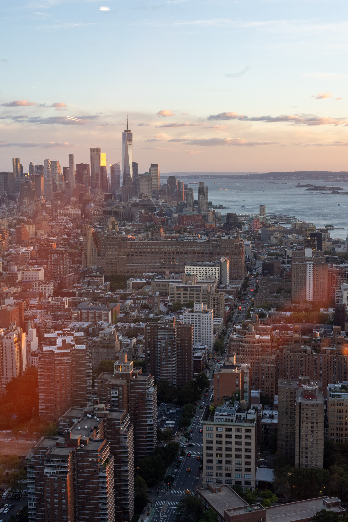 Lower Manhattan and the harbor at dusk from a high window.